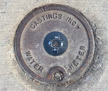 Meter Pit lid with the words Castings Inc Water Meter imprinted on the surface