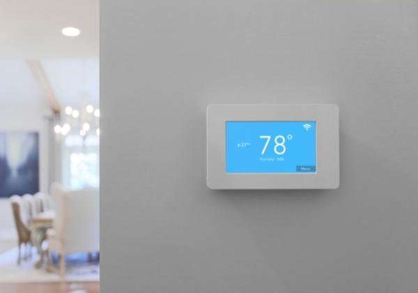 Smart thermostat on a hallway wall.