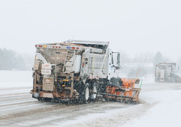 Two snow plows on a snowy road.